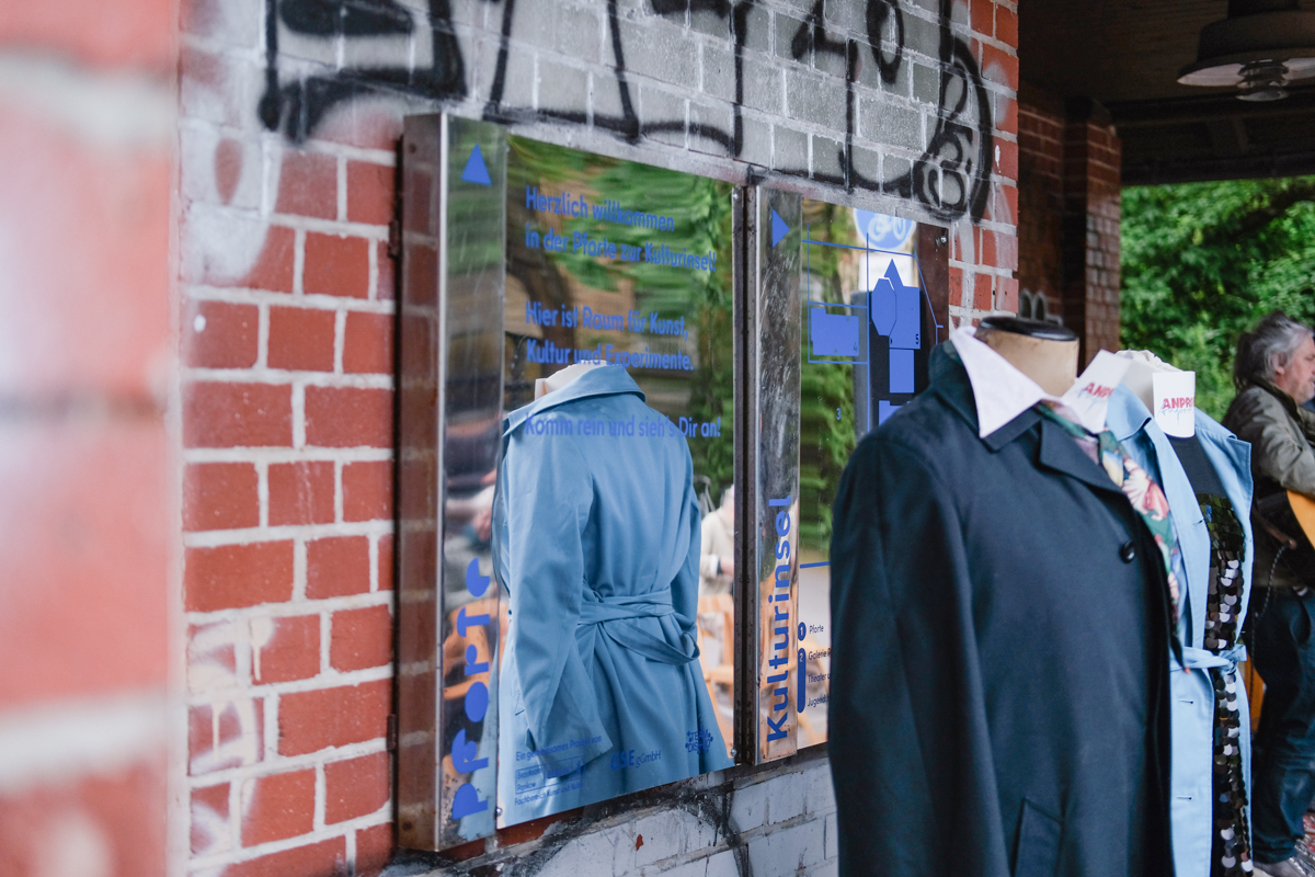 Foto von einem spiegelnden Schild vor einer Backsteinwand. 