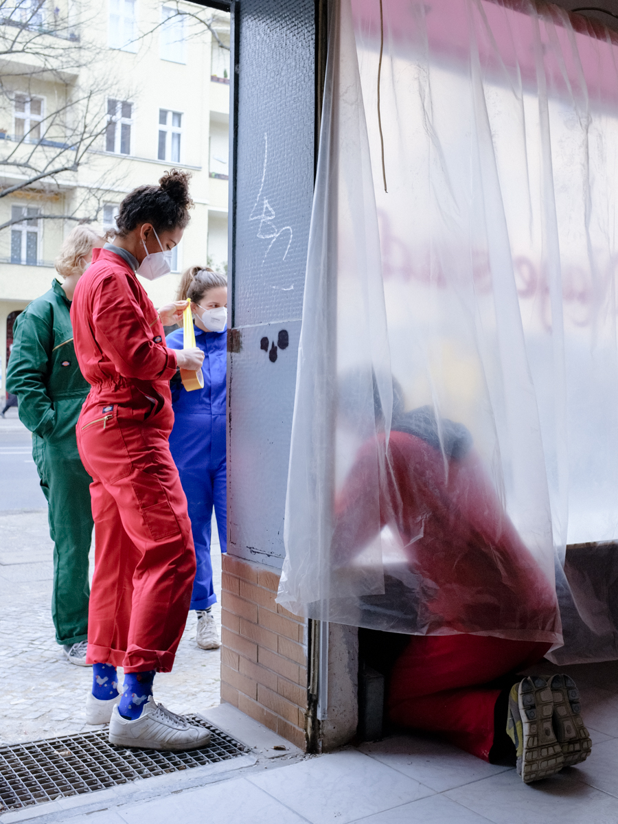 Personen auf Baustelle kleben Türrahmen ab.