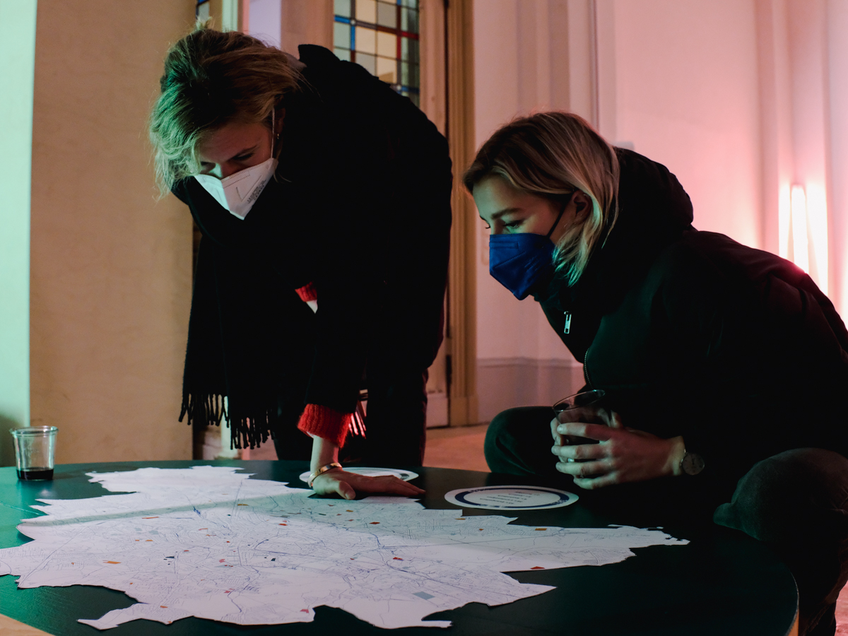Zwei Frauen beugen sich über eine Karte von Berlin.